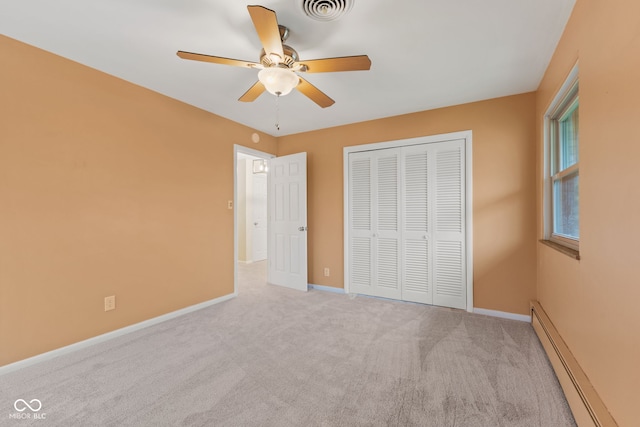 unfurnished bedroom featuring ceiling fan, a closet, light carpet, and a baseboard heating unit