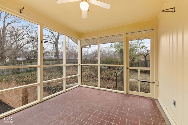 unfurnished sunroom with ceiling fan