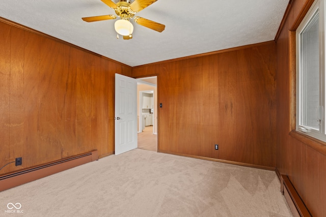 unfurnished room featuring a baseboard radiator, ceiling fan, and wooden walls