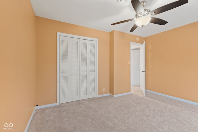 unfurnished bedroom featuring light carpet, a closet, and ceiling fan