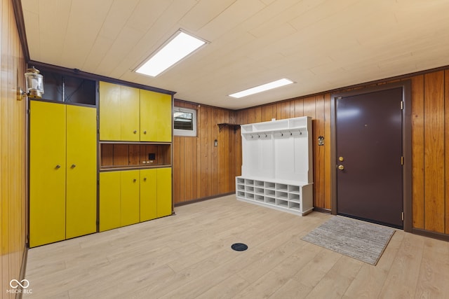 interior space featuring light wood-type flooring and wooden walls