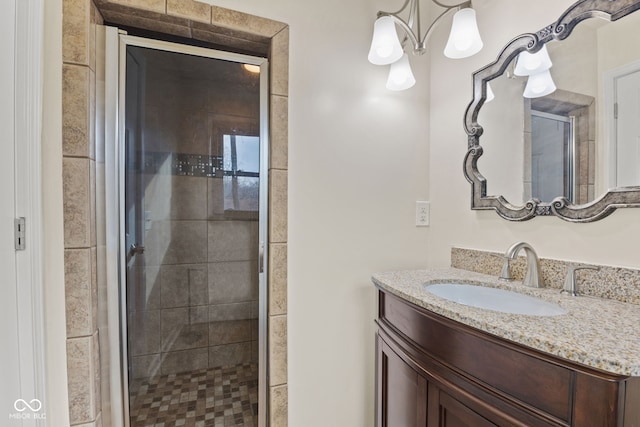 bathroom with vanity, an enclosed shower, and an inviting chandelier