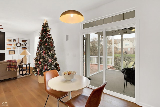 dining space featuring wood-type flooring and ceiling fan