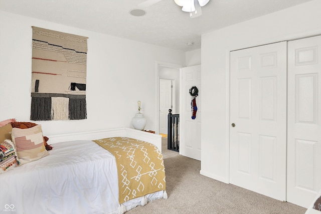 carpeted bedroom featuring ceiling fan and a closet