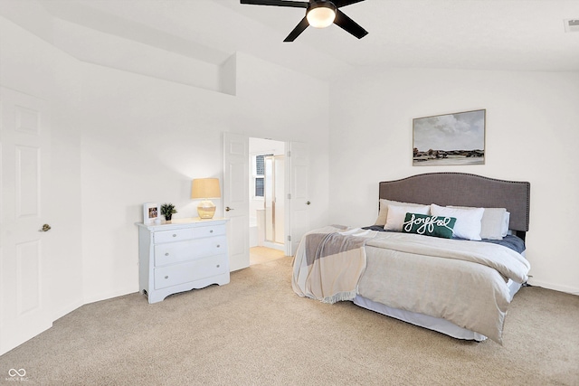 bedroom featuring connected bathroom, light carpet, ceiling fan, and lofted ceiling