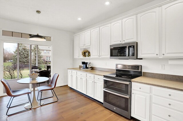 kitchen with white cabinetry, hardwood / wood-style floors, pendant lighting, and appliances with stainless steel finishes