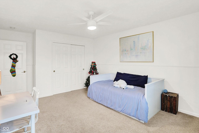 carpeted bedroom with ceiling fan and a closet