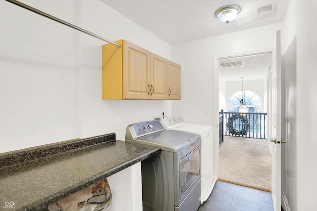 laundry area with carpet flooring, washer and clothes dryer, cabinets, and a textured ceiling