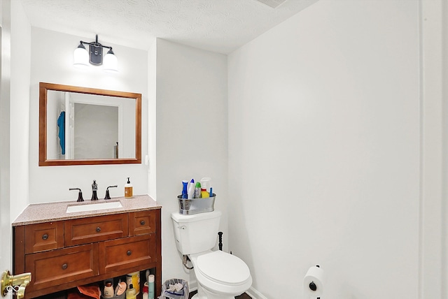 bathroom featuring vanity, toilet, and a textured ceiling