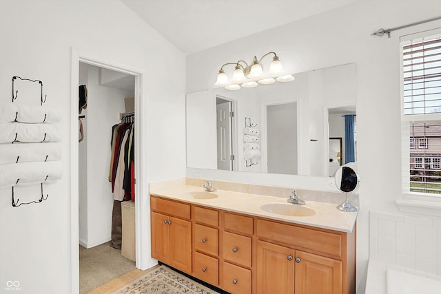 bathroom featuring tile patterned flooring, vanity, and vaulted ceiling