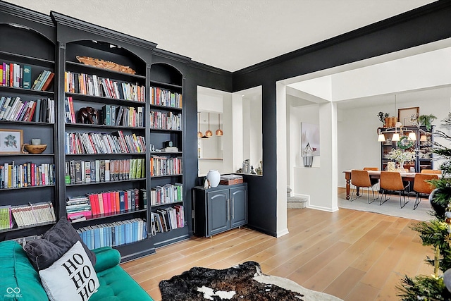 living area featuring light hardwood / wood-style floors and crown molding