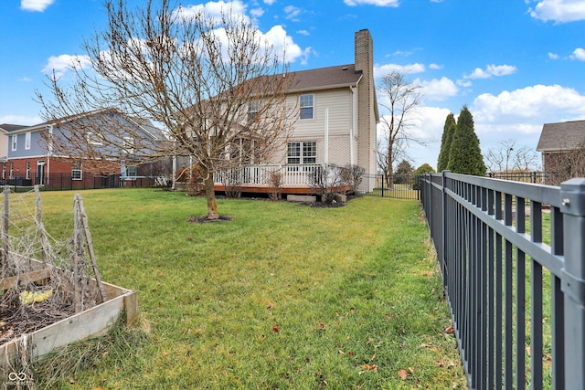 rear view of property with a yard and a wooden deck