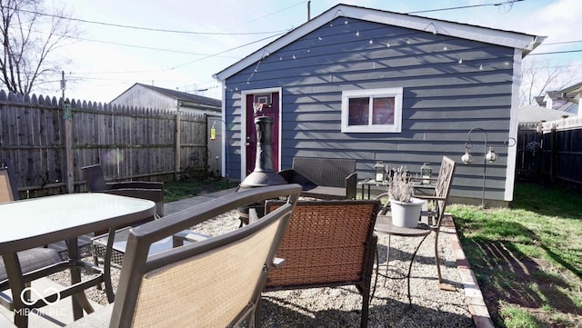 back of property featuring a patio area, outdoor dining area, and a fenced backyard