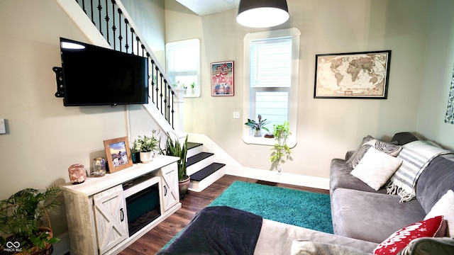 living room with dark wood-type flooring and stairs