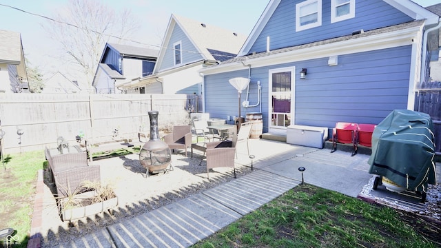 view of patio featuring grilling area, fence, and a fire pit