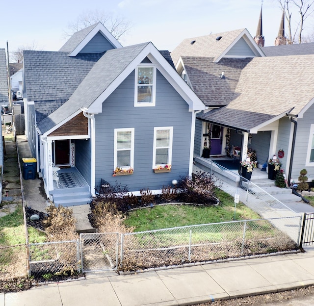 view of front of home with a gate, covered porch, a fenced front yard, and a shingled roof