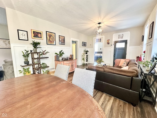 living area with a wainscoted wall and wood finished floors