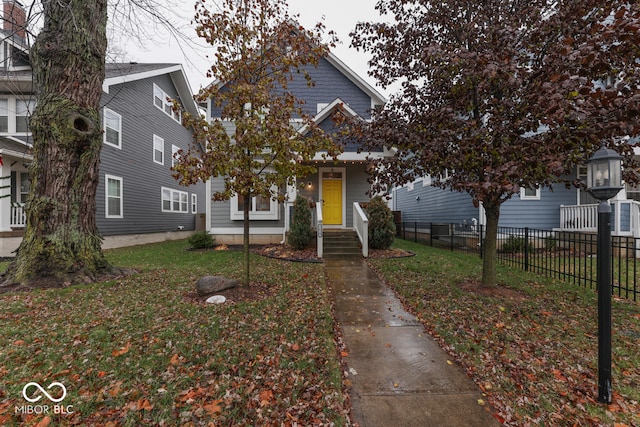 view of property hidden behind natural elements with a front lawn