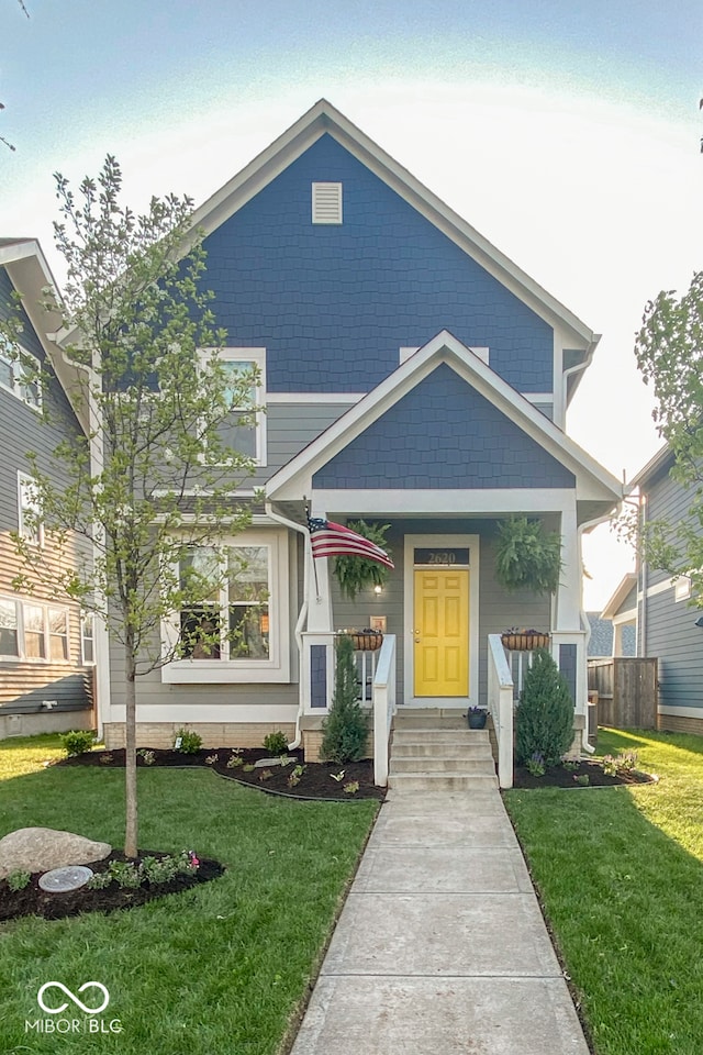 view of front of home with covered porch and a front yard