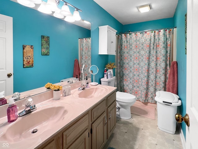 bathroom featuring toilet, vanity, and curtained shower