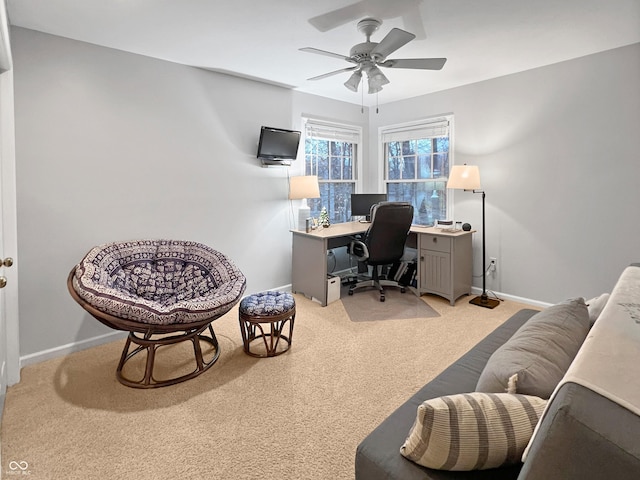 carpeted office space featuring ceiling fan