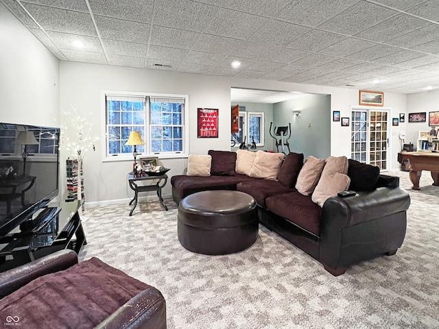 carpeted living room featuring a drop ceiling