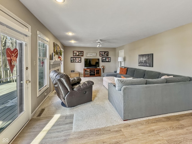 living room featuring light hardwood / wood-style floors and ceiling fan