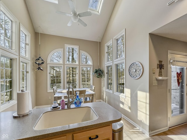 kitchen with a healthy amount of sunlight, high vaulted ceiling, sink, and ceiling fan