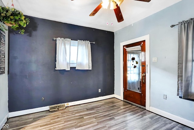 foyer entrance with ceiling fan and wood-type flooring