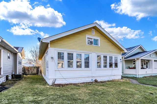 back of house featuring a lawn and central air condition unit