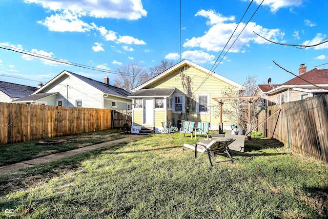 rear view of house featuring a lawn