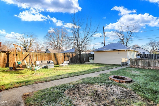 view of yard with an outdoor living space with a fire pit