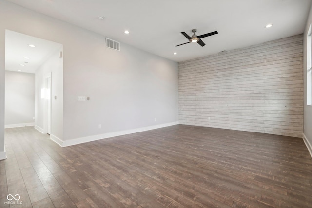 spare room with dark hardwood / wood-style flooring and ceiling fan