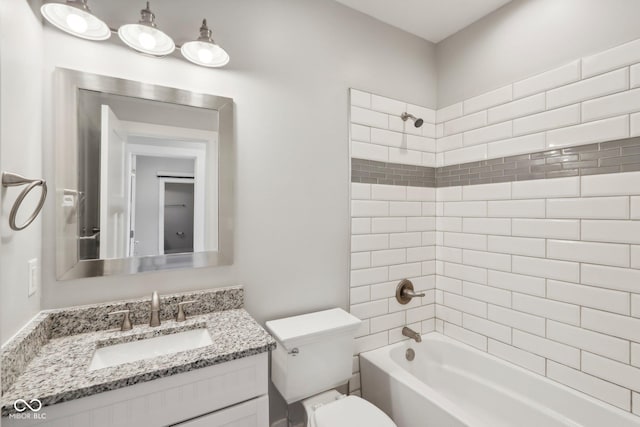 full bathroom with tiled shower / bath combo, toilet, and vanity