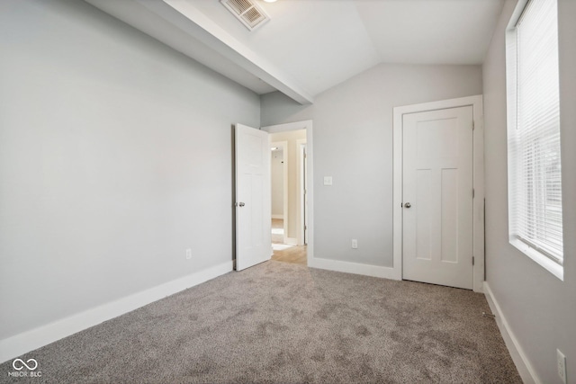 unfurnished bedroom with carpet and lofted ceiling