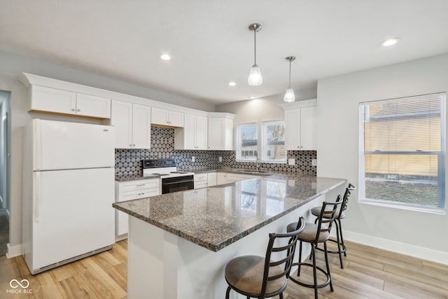 kitchen with white cabinets, light wood-type flooring, and white appliances