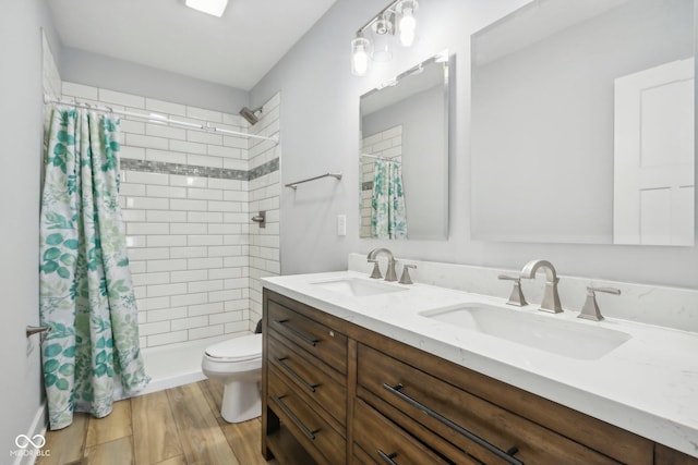 bathroom featuring curtained shower, toilet, vanity, and hardwood / wood-style flooring