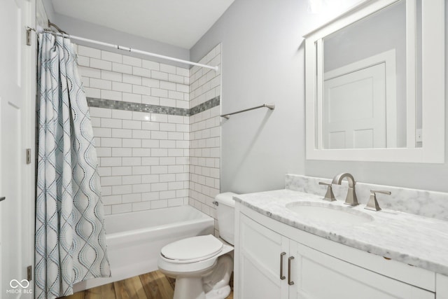 full bathroom with hardwood / wood-style floors, vanity, shower / tub combo, and toilet