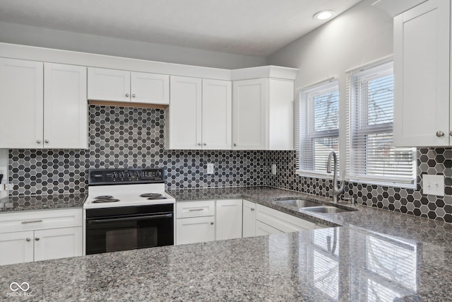 kitchen featuring white cabinets, electric range, stone counters, and sink