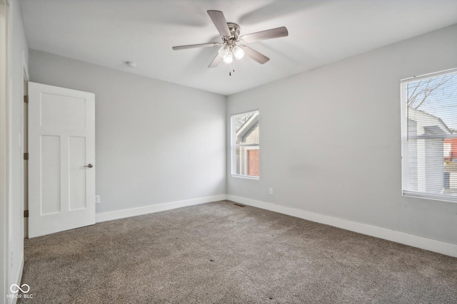 spare room with plenty of natural light, ceiling fan, and carpet floors