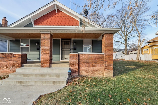 view of front of house featuring covered porch and a front yard