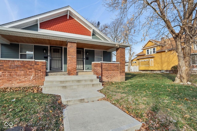 view of front of house with a front yard and a porch