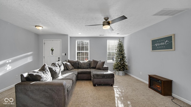 carpeted living room featuring ceiling fan and a textured ceiling