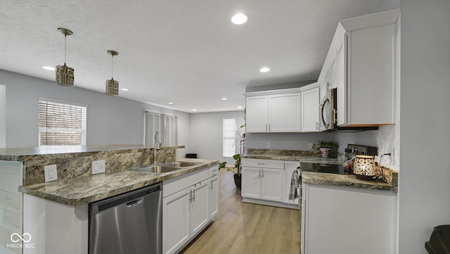 kitchen with appliances with stainless steel finishes, white cabinetry, pendant lighting, and sink