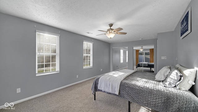 bedroom featuring carpet flooring, ceiling fan, and a textured ceiling