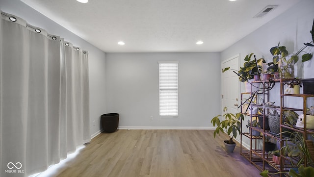 spare room with a textured ceiling and light wood-type flooring