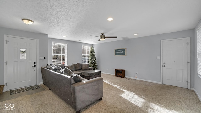 living room with carpet, ceiling fan, and a textured ceiling