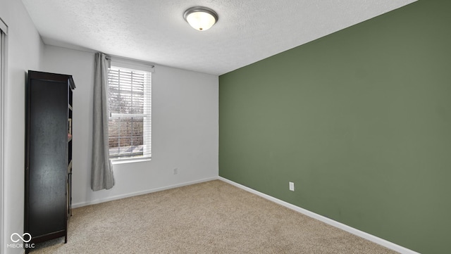 carpeted empty room featuring a textured ceiling