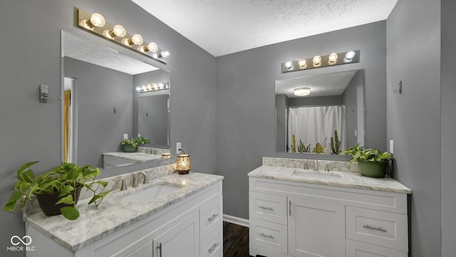 bathroom featuring vanity, wood-type flooring, and a textured ceiling