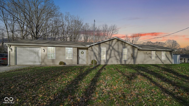 ranch-style house featuring a lawn and a garage